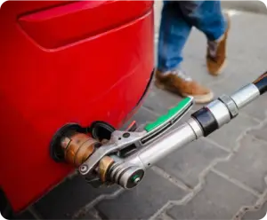 Pistolet de remplissage GPL raccordé à l’adaptateur d’un véhicule lors d’une opération de ravitaillement.