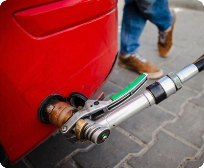 Pistolet de remplissage GPL raccordé à l’adaptateur d’un véhicule lors d’une opération de ravitaillement.