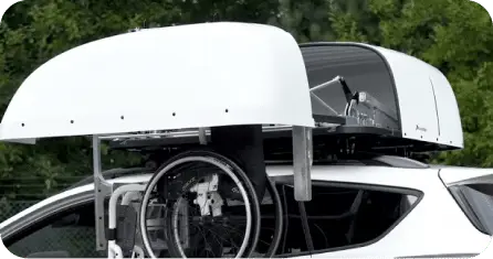 Coffre de toit automatisé pour stocker un fauteuil roulant sur un véhicule adapté au handicap