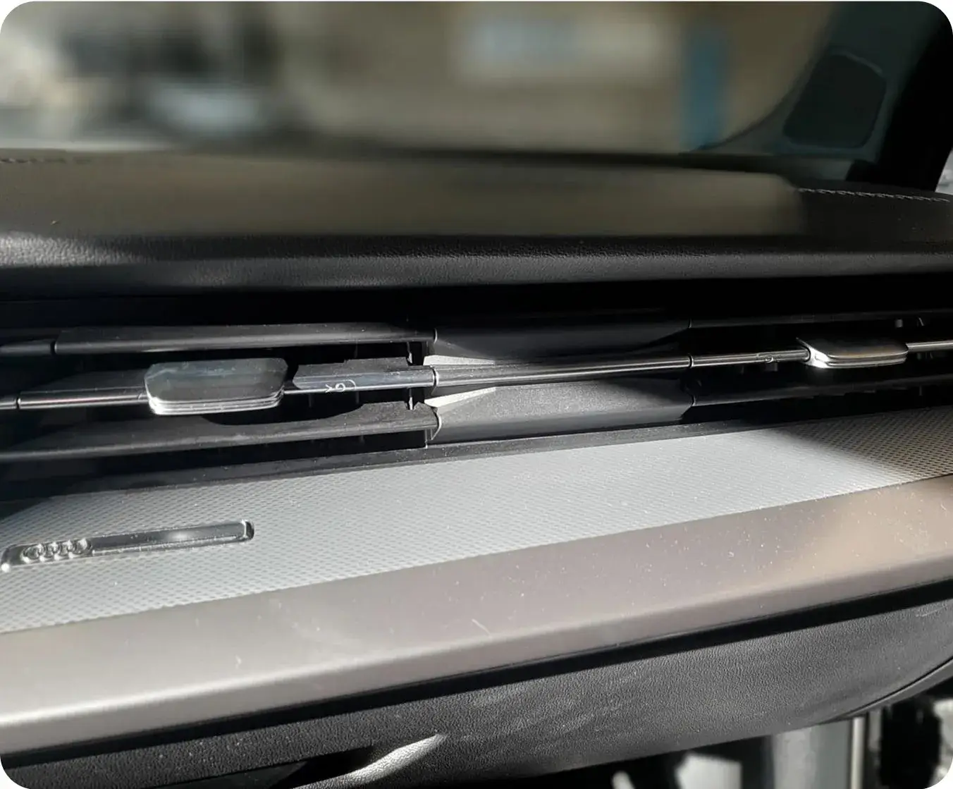 Sorties d’aération circulaires sur la console d’un véhicule, illustrant le système de ventilation et de climatisation.