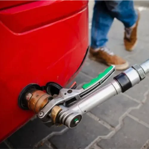 Pistolet de remplissage GPL raccordé à l’adaptateur d’un véhicule lors d’une opération de ravitaillement.